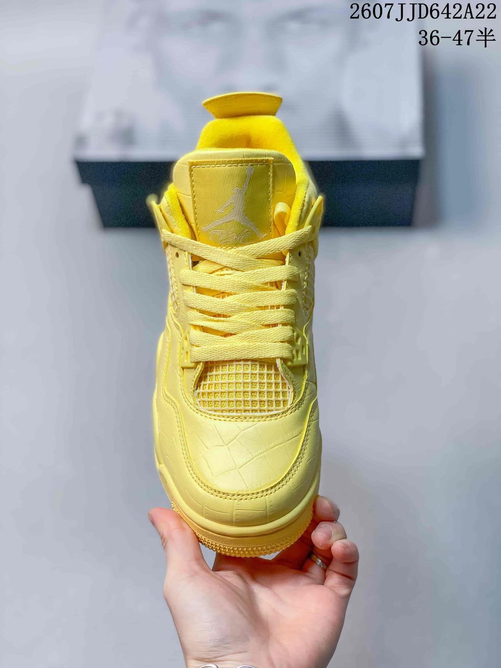 Front view of the yellow sneaker showing the tongue branding, flat laces and textured toe box.