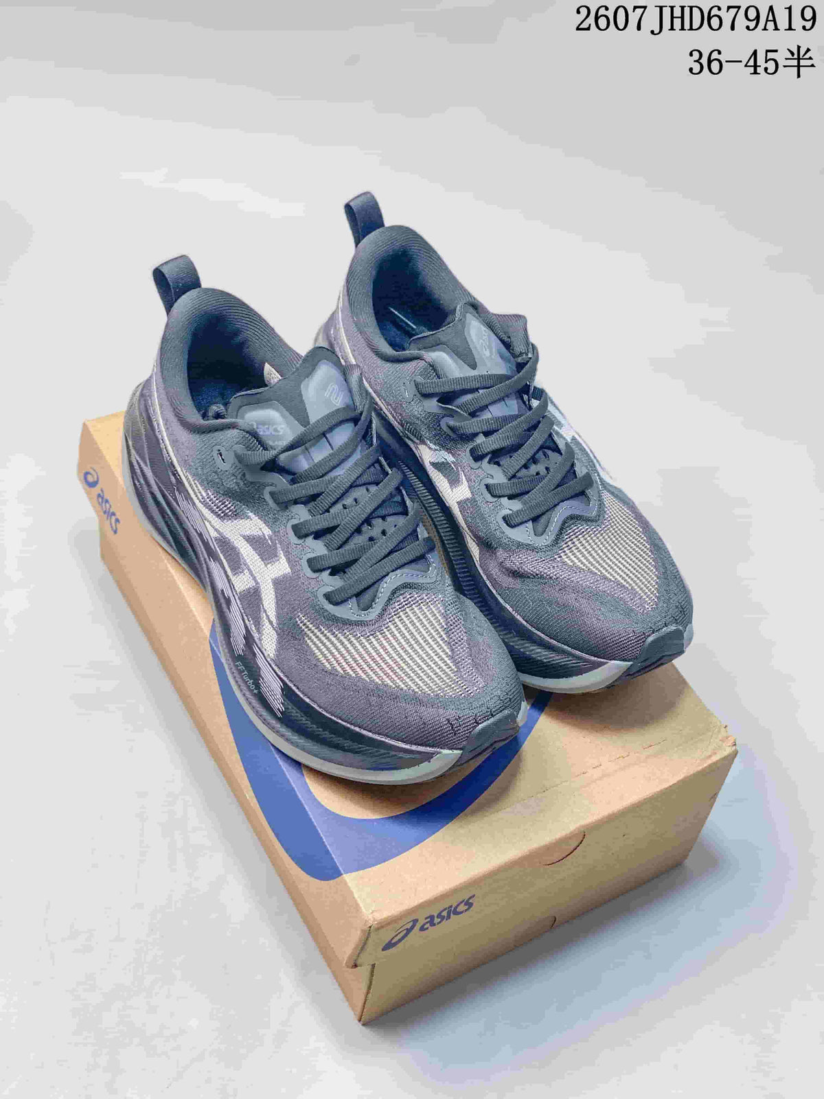 Pair of gray ASICS Superblast 2 Paris running sneakers displayed on an ASICS shoebox.