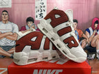 Pair of off-white and brown Nike sneakers displayed at an angle, showing the AIR side design and chunky sole.