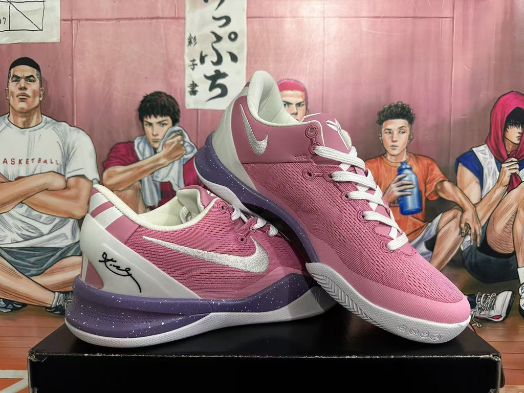 Pair of pink basketball shoes shown together, with white laces, white heel panels, and purple-speckled midsoles.