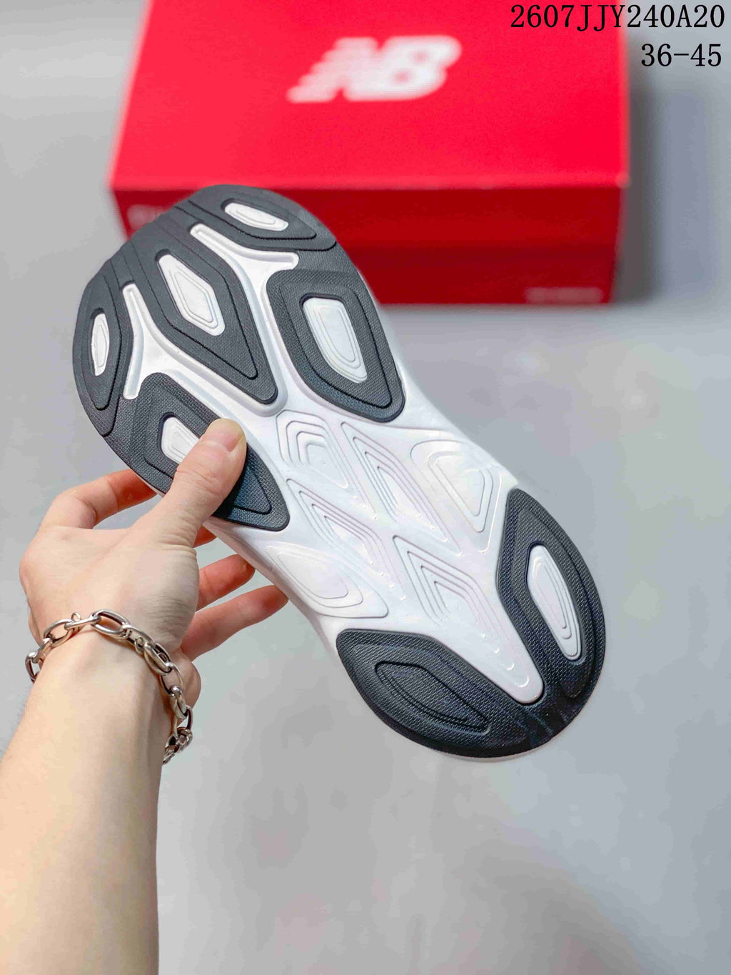Close-up of the patterned outsole with dark gray traction sections and white detailing.
