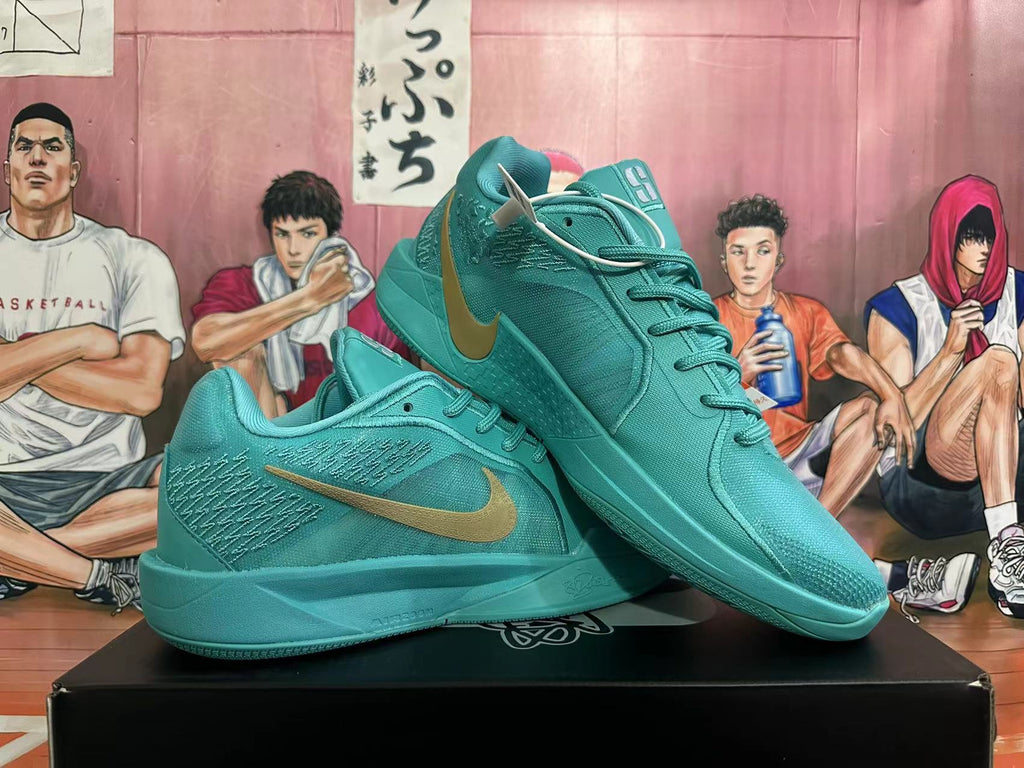 Pair of lake-blue Nike Kobe basketball shoes showing the side panels, laces, and gold-tone Swoosh.