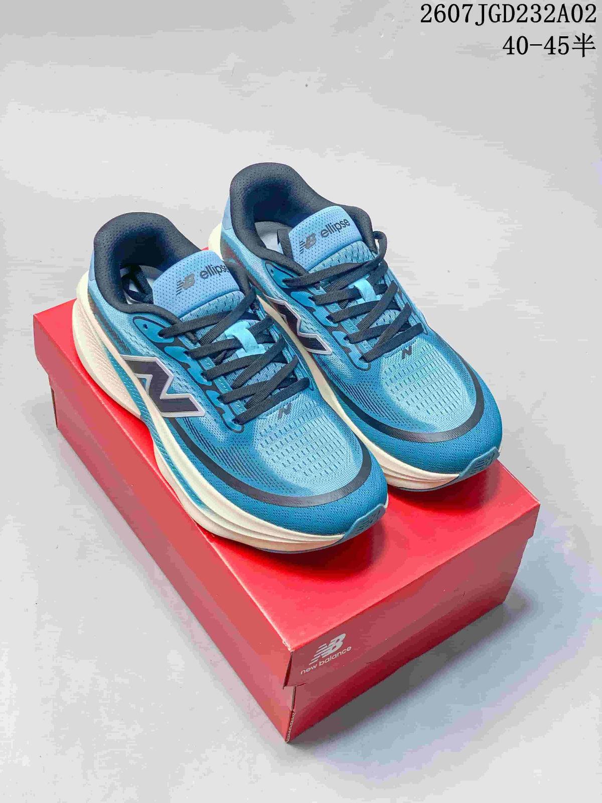 Pair of blue New Balance Ellipse running shoes with dark laces on a red shoebox
