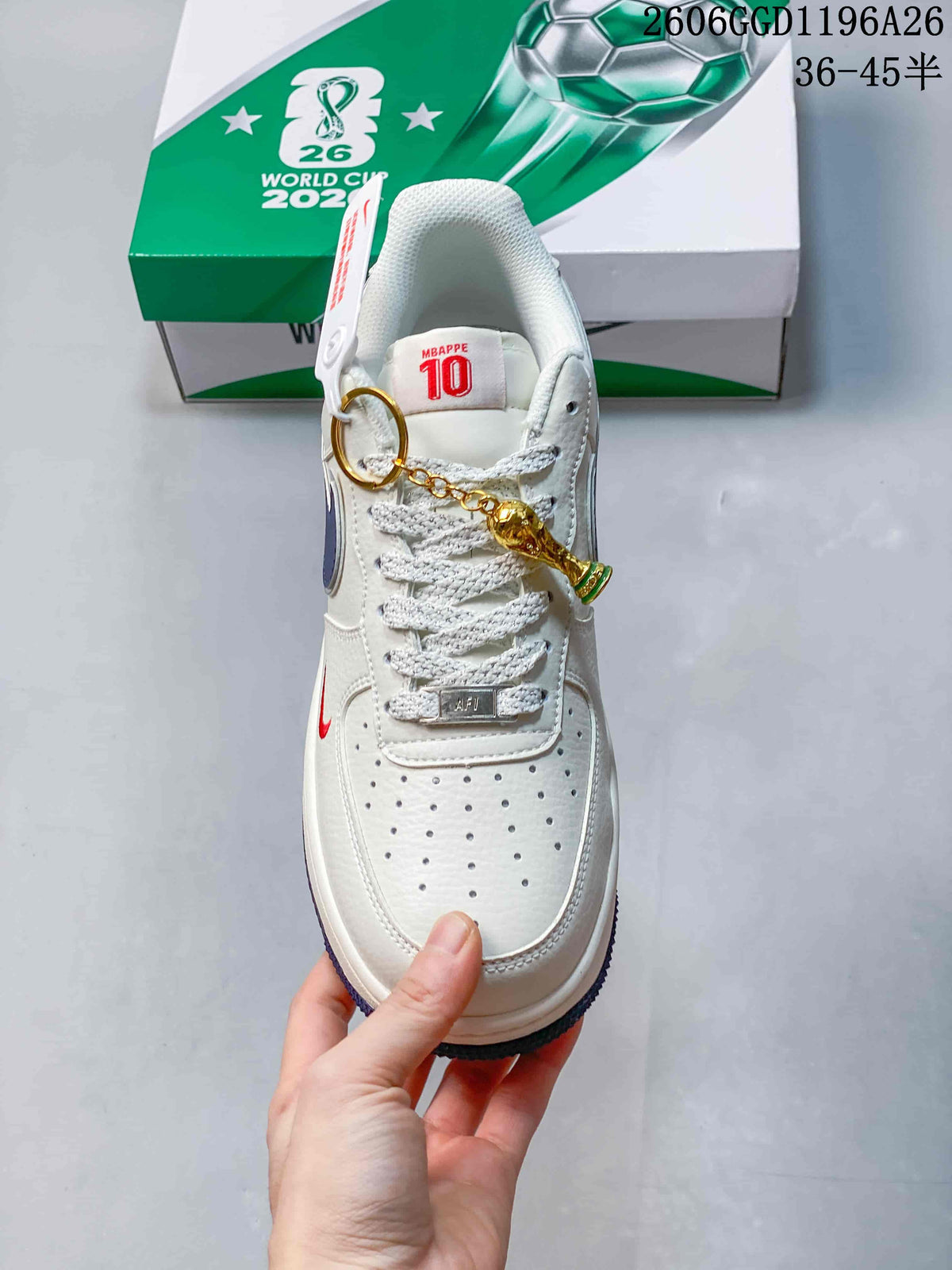 Top view showing perforated toe, textured laces, red details, and a gold-tone charm.