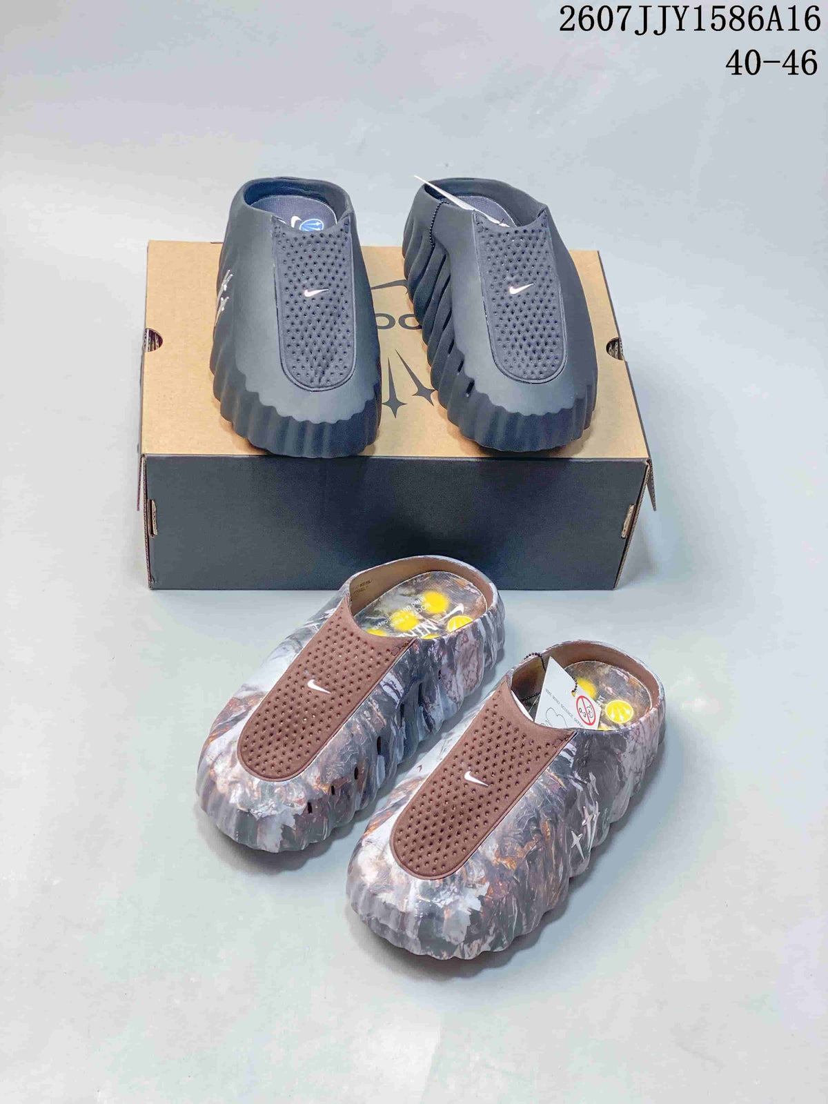 Front view showing black and gray slides on a box and brown multicolor slides in the foreground; image text shows style code 2607JJY1586A16 and size range 40–46.