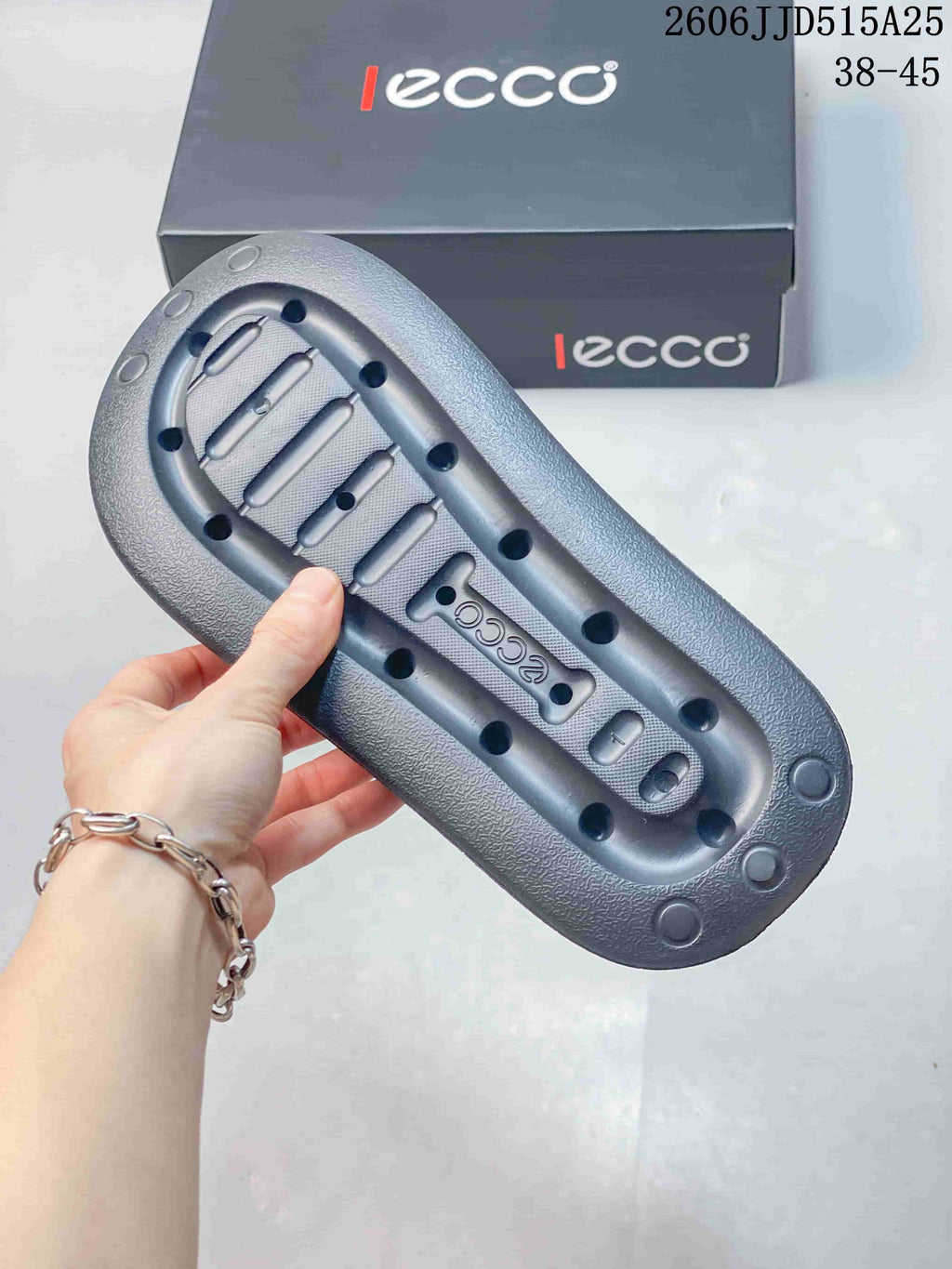 Underside of a dark gray sandal showing the textured sole pattern and ECCO branding.