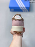 Rear view of a pink sneaker showing the brown textured collar trim, heel stitching and cream midsole.
