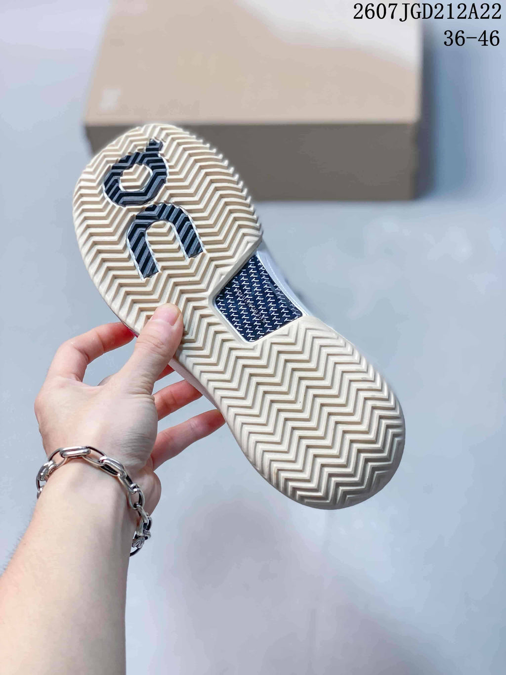 Underside view of the sneaker showing the cream-colored zigzag outsole pattern and On branding.