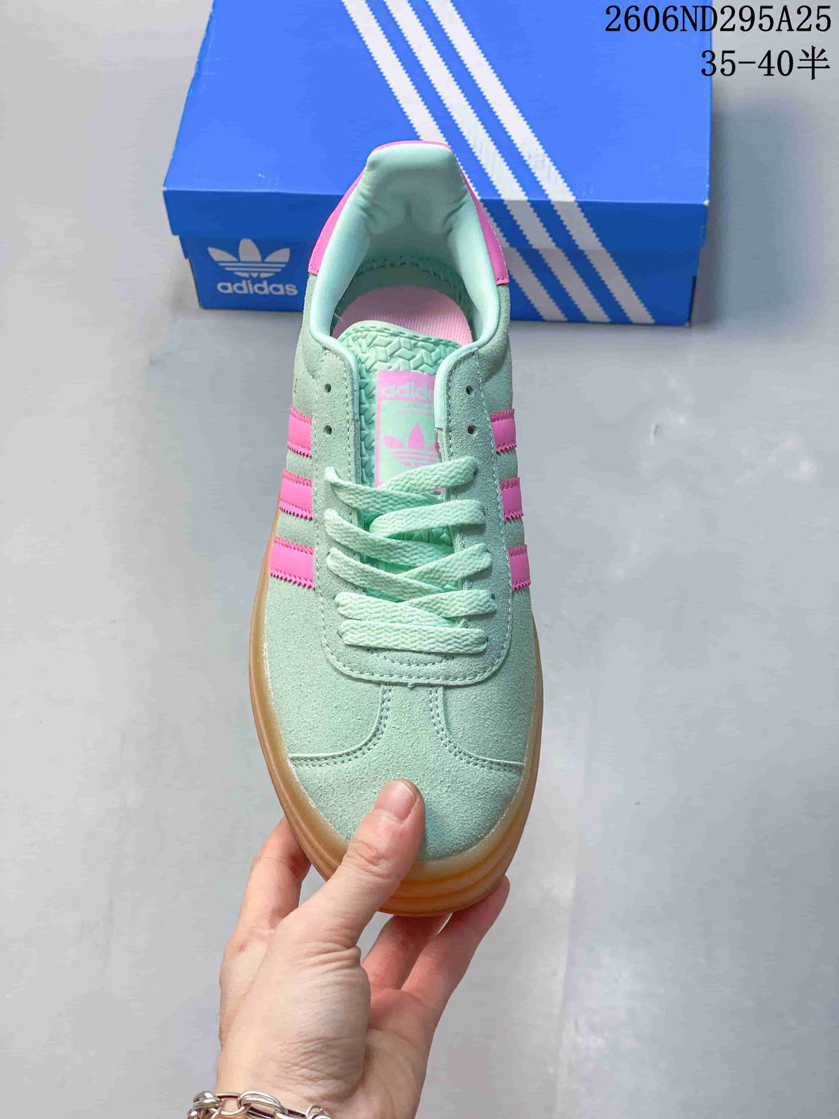 Top view of the mint green lace-up sneaker with pink branding details and rounded toe.