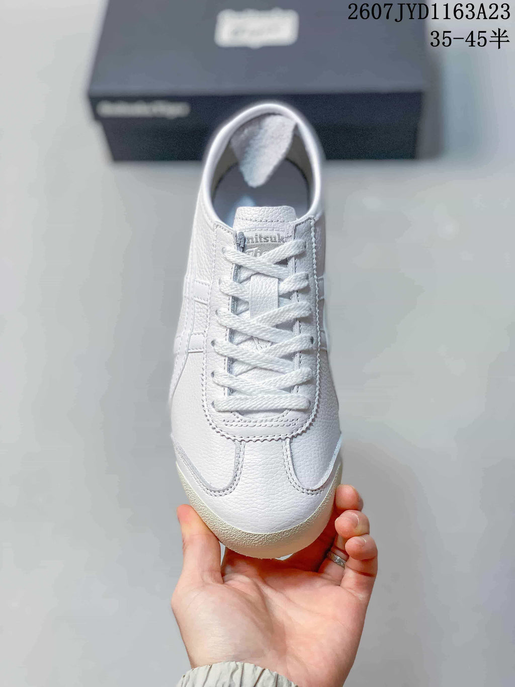Top view showing the white lace-up sneaker with a rounded toe and pink detailing.