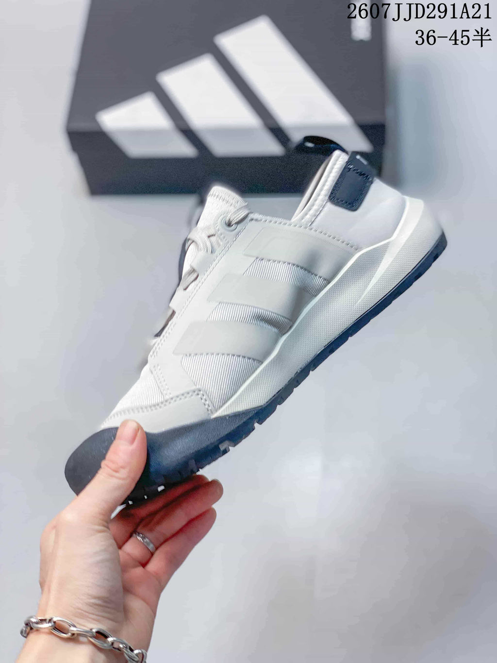 Side view showing the white upper, layered side panels, lace-up design and dark outsole.