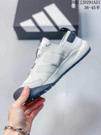 Side view showing the white upper, layered side panels, lace-up design and dark outsole.