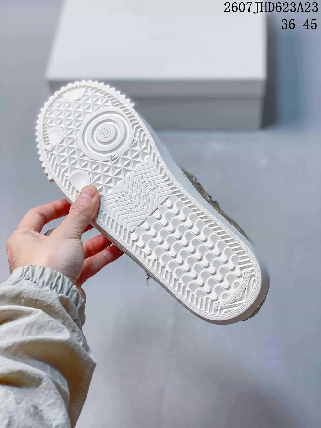 Close view of the white textured rubber outsole with patterned tread.