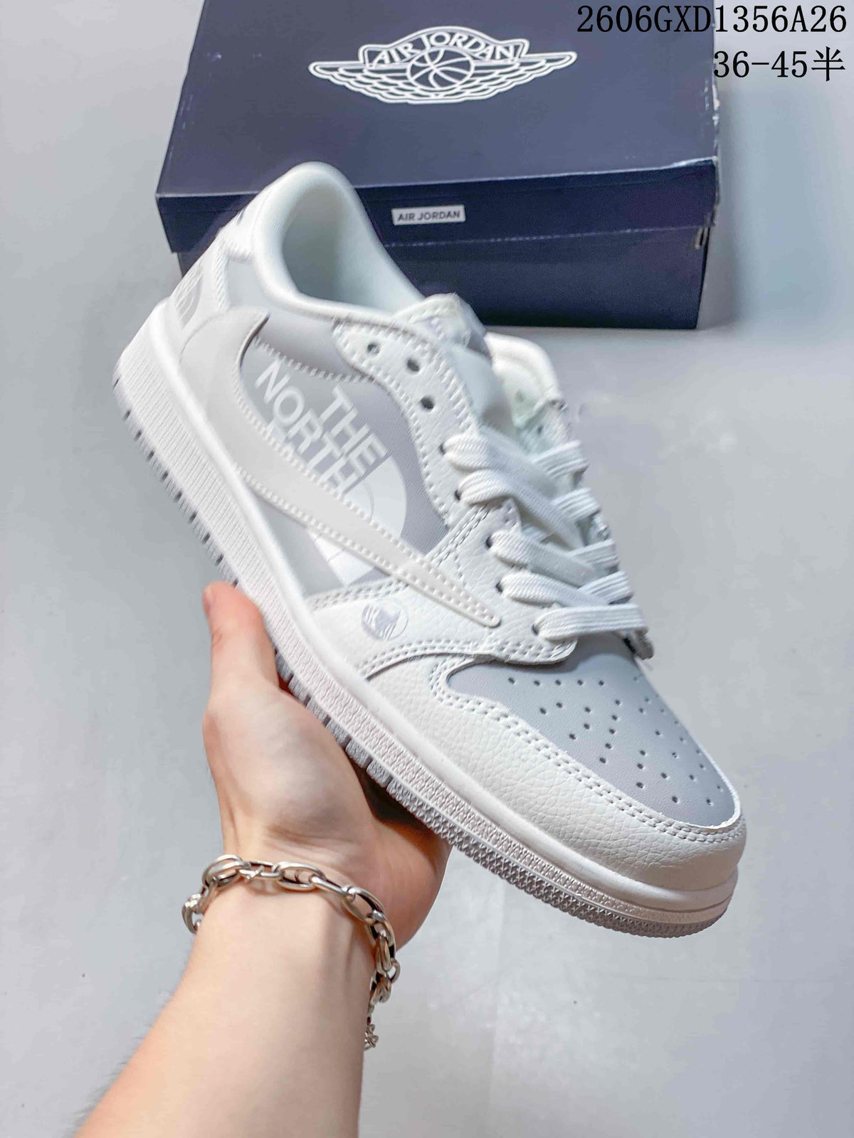 Angled view of a white and light-grey low-top sneaker with contrasting side-panel graphics