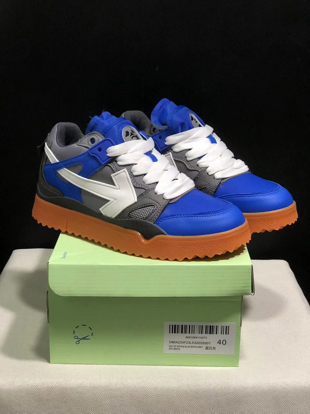 Three-quarter view of the sneakers on a green shoebox; the box label visibly shows size 40 and identifies the Out Of Office model.