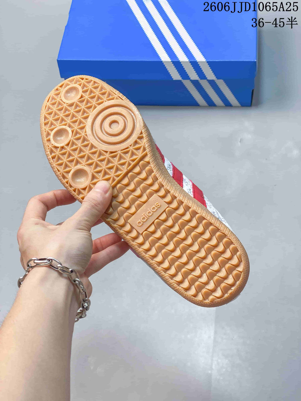 Close view of the gum-colored outsole showing circular forefoot details and a patterned tread with Adidas branding.