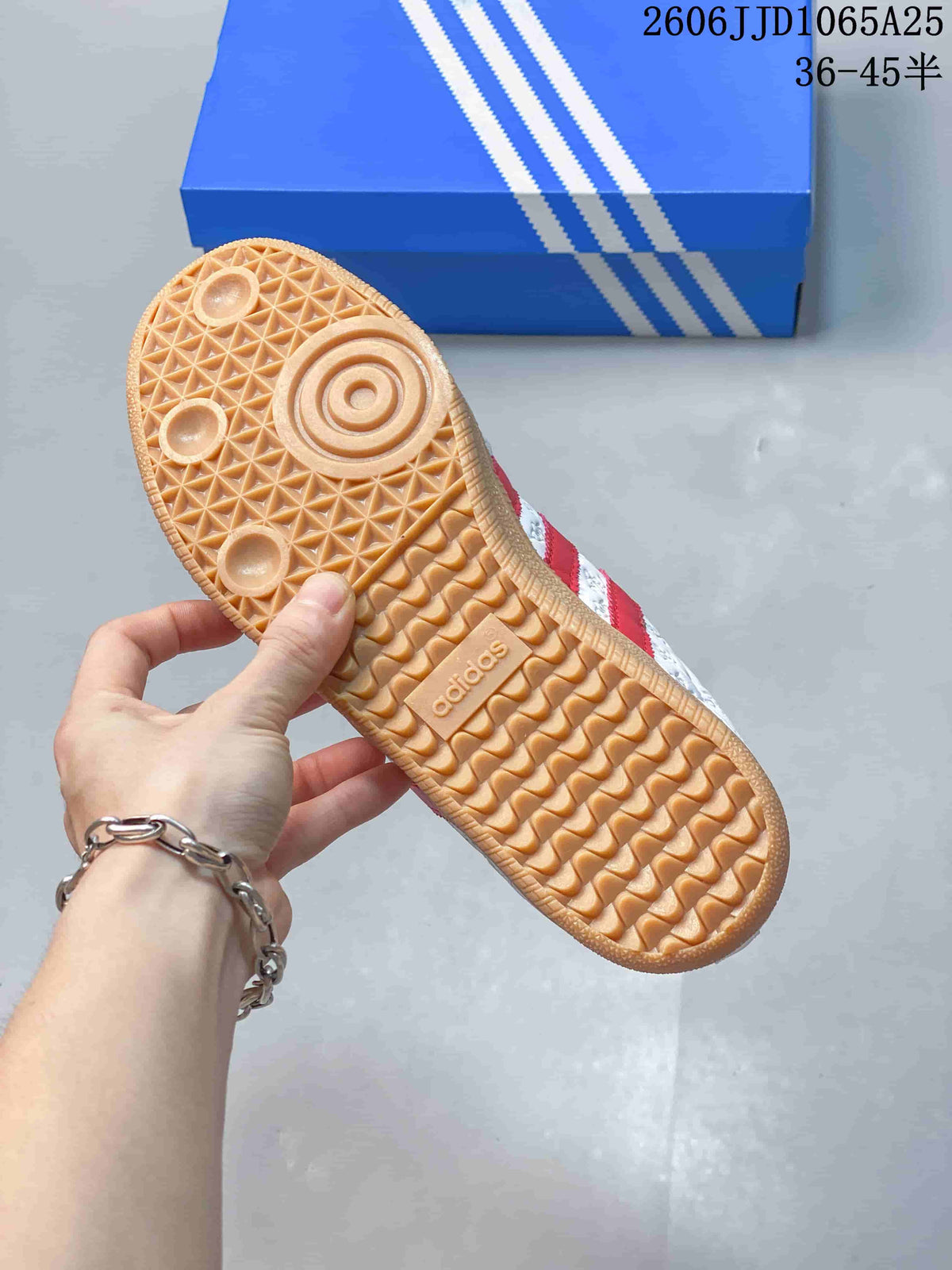 Close view of the gum-colored outsole showing circular forefoot details and a patterned tread with Adidas branding.