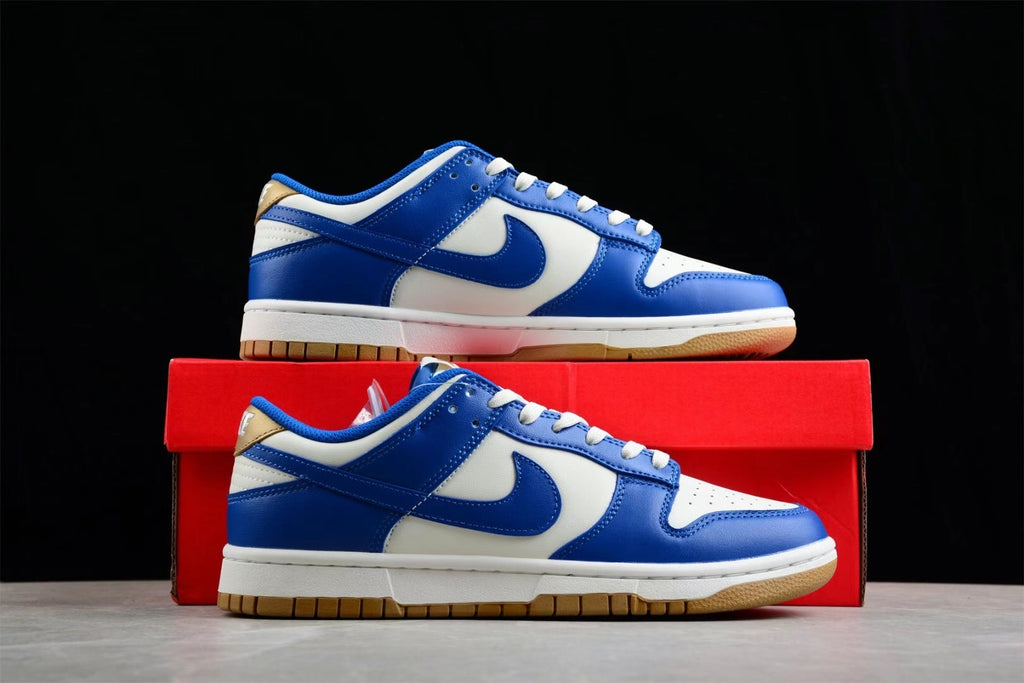 Two white and blue sneakers displayed in front of a red shoebox.