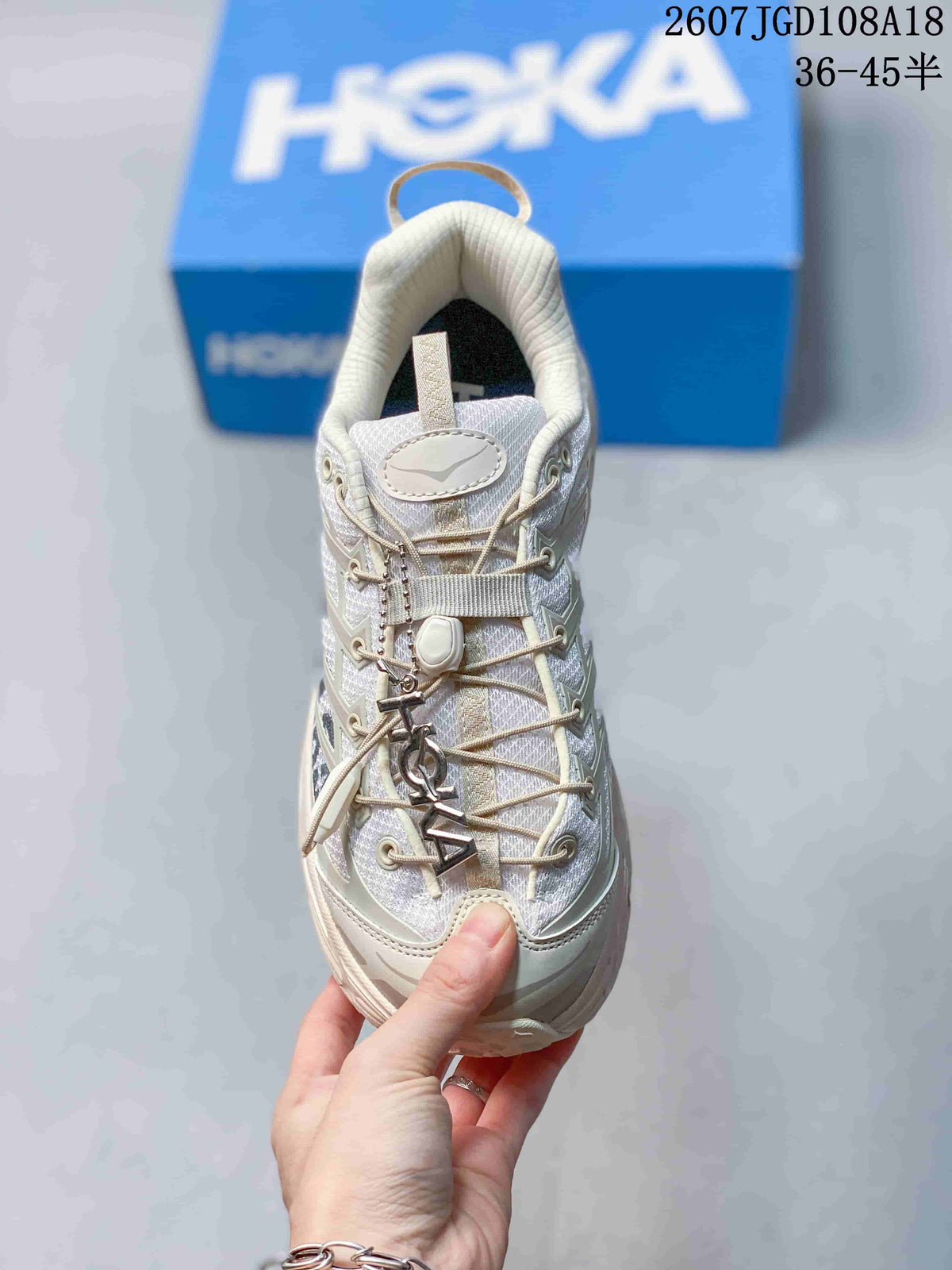 Front view of the sneaker showing the lace-up closure, toggle-style detail, padded tongue and rounded toe.