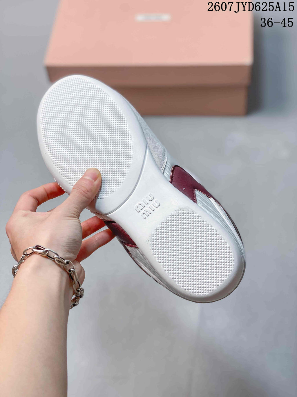 Underside view of a white sneaker showing the textured outsole and embossed Miu Miu branding, with size range 36–45 visible.
