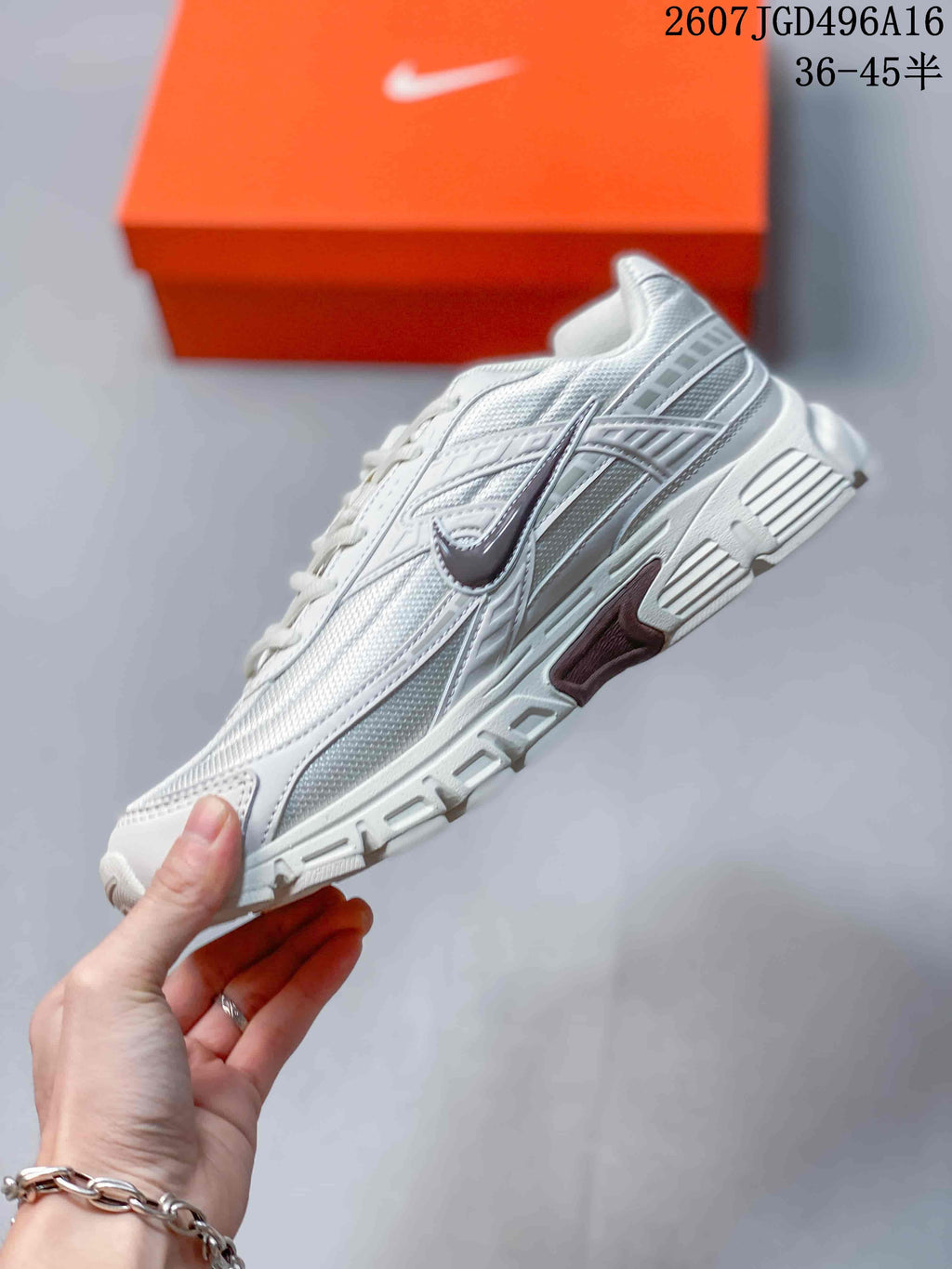 Side view of a white and grey Nike Initiator sneaker showing the layered upper, Nike Swoosh and textured outsole.