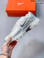 Side view of a white and grey Nike Initiator sneaker showing the layered upper, Nike Swoosh and textured outsole.
