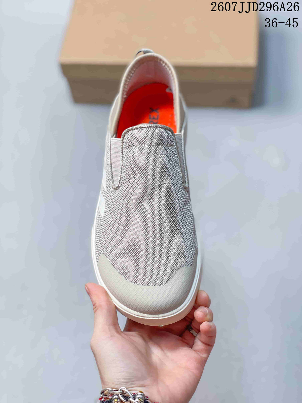 Top view showing the light gray textile-look upper, wide tongue panel, and orange interior lining.