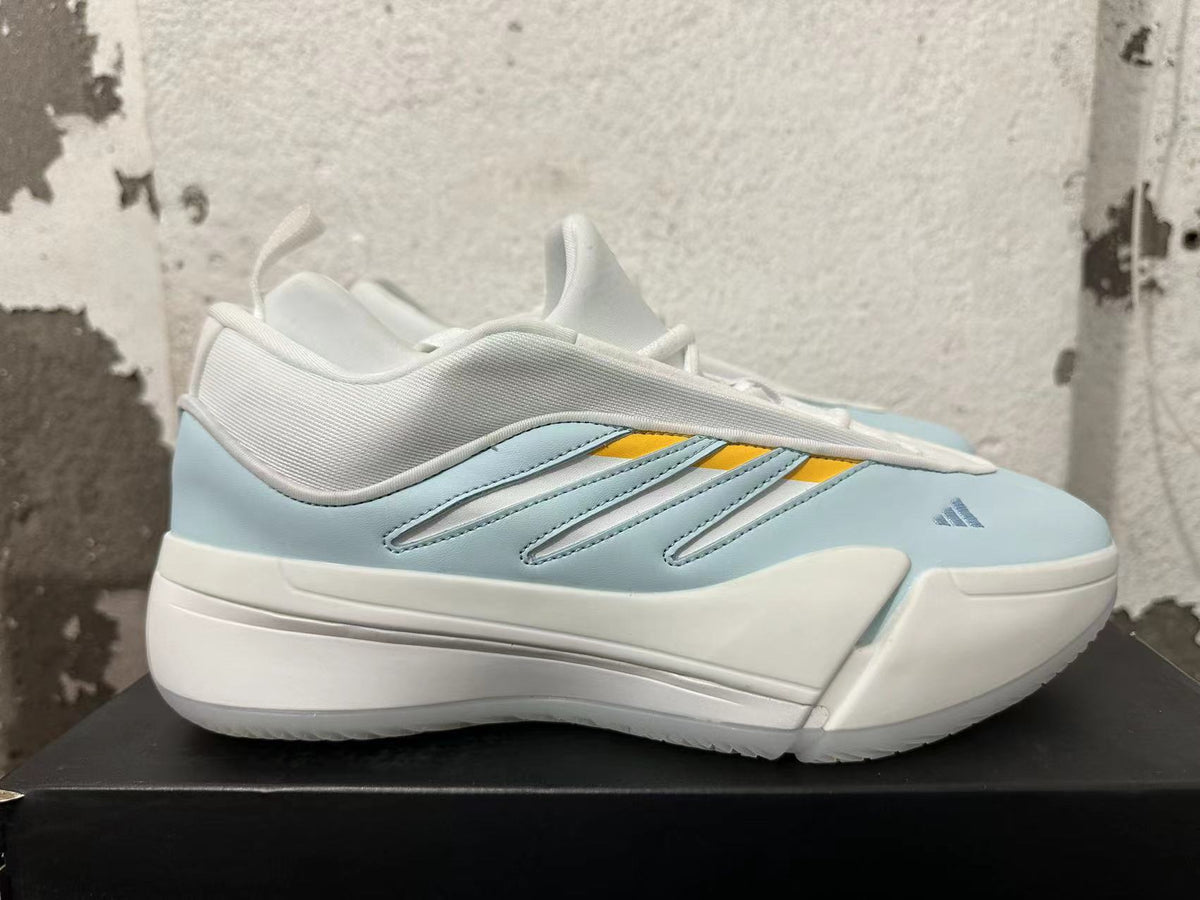 Side profile of a light blue Adidas Dame 9 shoe with white and yellow details