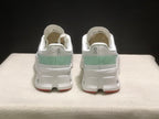 Rear view of the pair showing the On branding, pale green heel panels, padded collars, and red outsole accents.