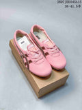 Pair of pink Versace x Onitsuka Tiger low-top sneakers displayed on a branded shoebox.