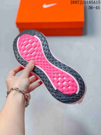 Close-up of the black-and-pink rubber outsole showing its textured tread pattern.