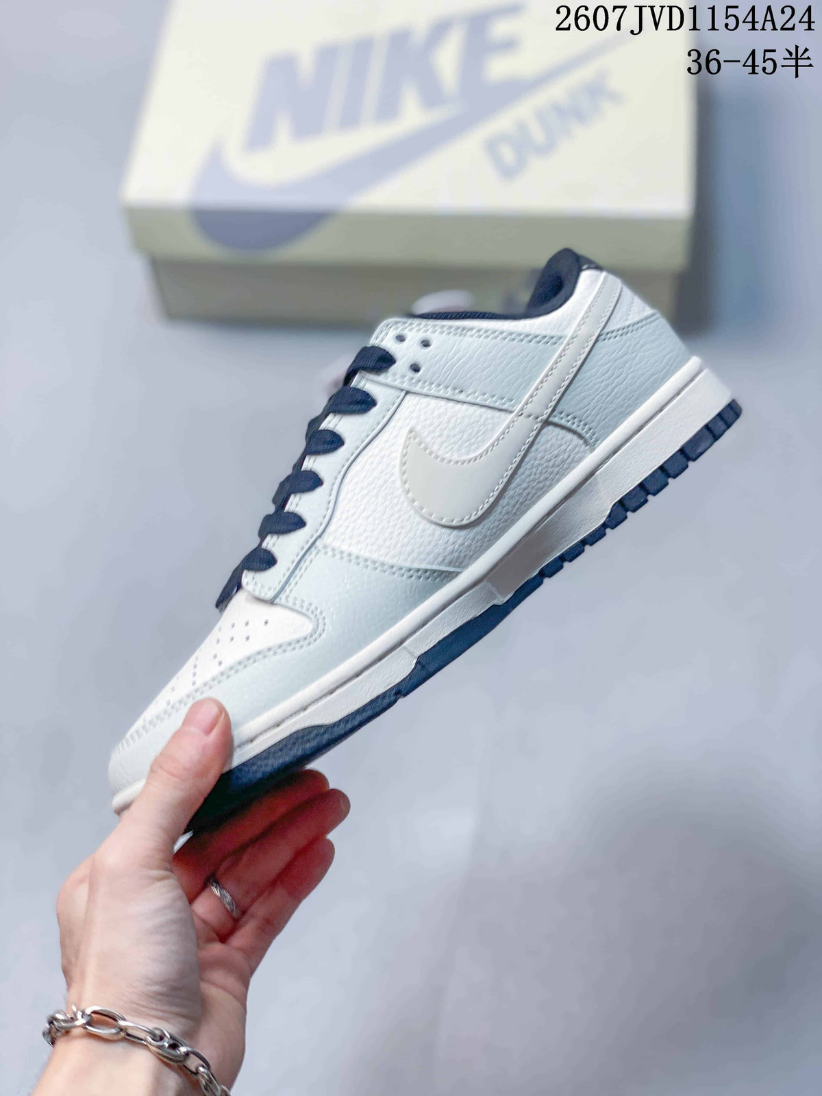 Side profile of a white and navy low-top sneaker showing the layered Swoosh, stitched panels and dark outsole.