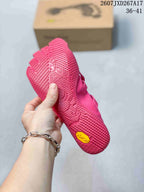 Underside view of a pink five-finger shoe showing the textured outsole and yellow Vibram outsole badge.
