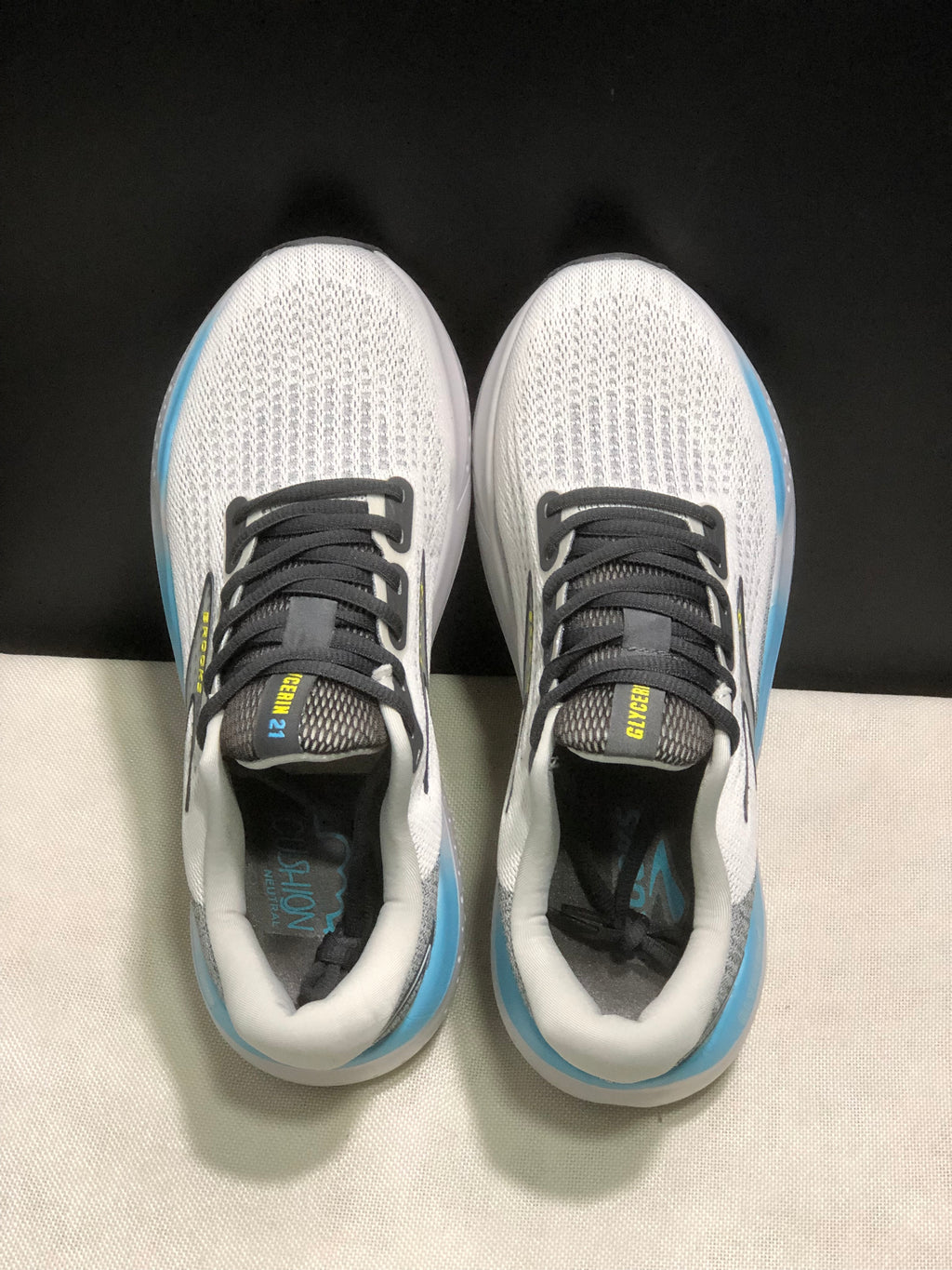 Top view of the Brooks Glycerin 21 pair, showing the white textured uppers, black laces, dark tongues, and padded white collars.