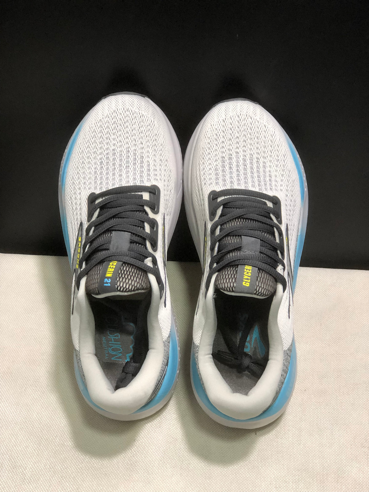 Top view of the Brooks Glycerin 21 pair, showing the white textured uppers, black laces, dark tongues, and padded white collars.