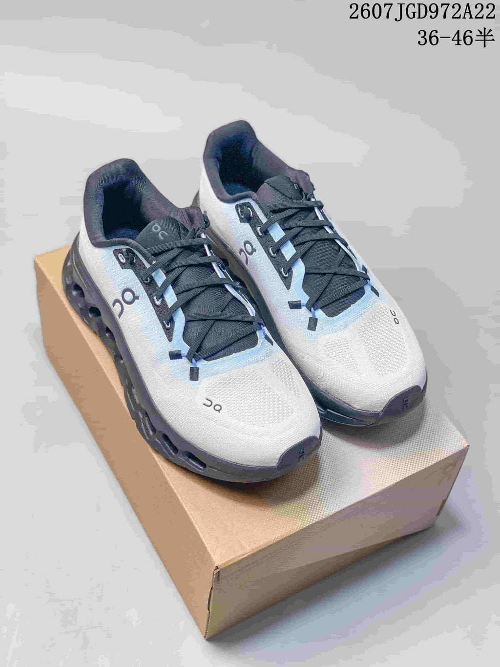 Pair of white and black On Cloudtilt low-top sneakers displayed on a cardboard shoe box.