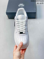 Front view of a white lace-up sneaker with a perforated toe box.