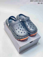 Pair of black perforated clog sandals with orange tread, shown on a shoe box; model text 2607JJD514A14 and size range 36–45 are visible.