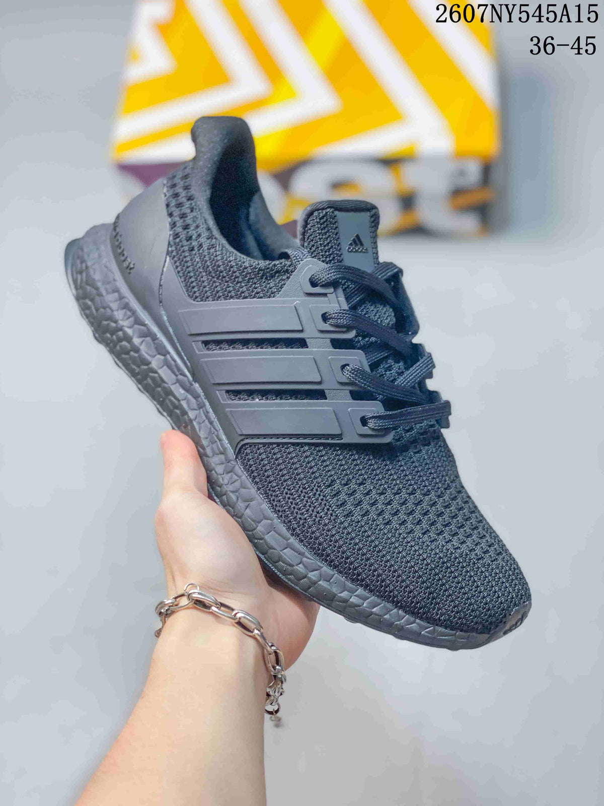 Angled side view of the dark gray Adidas sneaker showing the knitted upper, molded side cage, lace-up construction, and textured midsole.