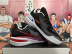 Pair of black basketball shoes with red and white detailing, shown from the side