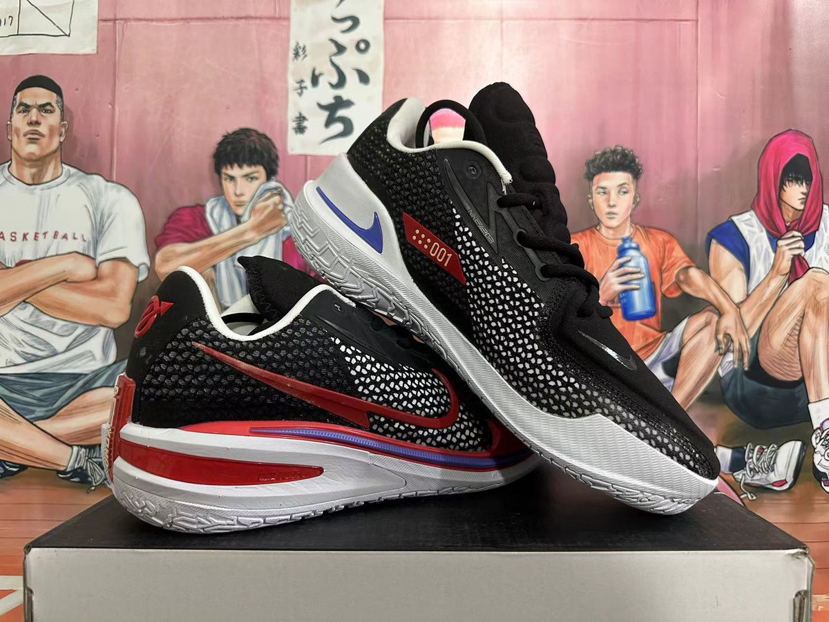 Pair of black basketball shoes with red and white detailing, shown from the side