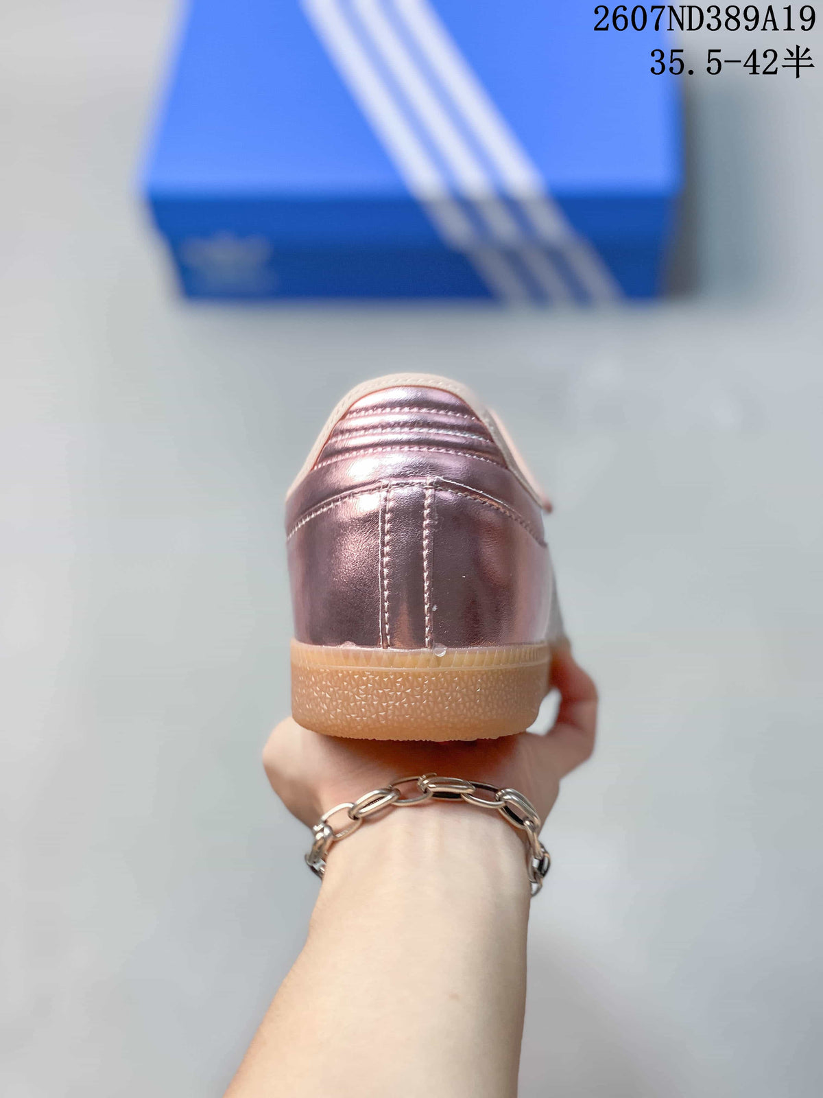 Rear view of the metallic pink sneaker showing the stitched heel panel and gum-colored sole.