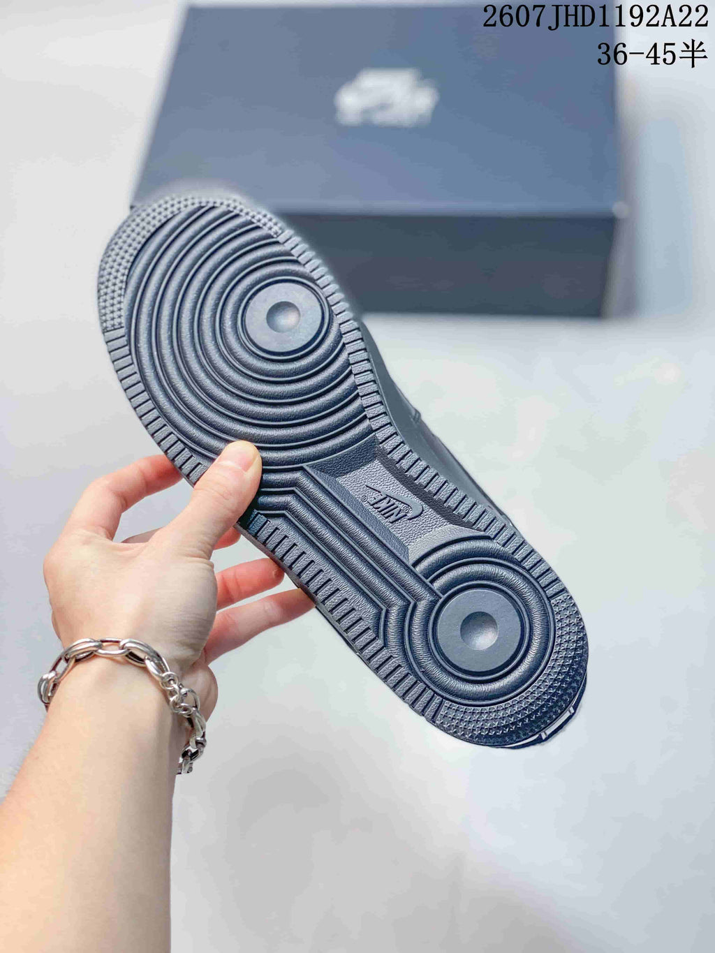 Close-up of the black sneaker outsole showing concentric circular traction grooves and a textured perimeter.