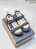 Pair of black and tan The North Face Explore Camp sandals displayed on a shoebox; style code JGD240A20 and size range 36–45 are visible.