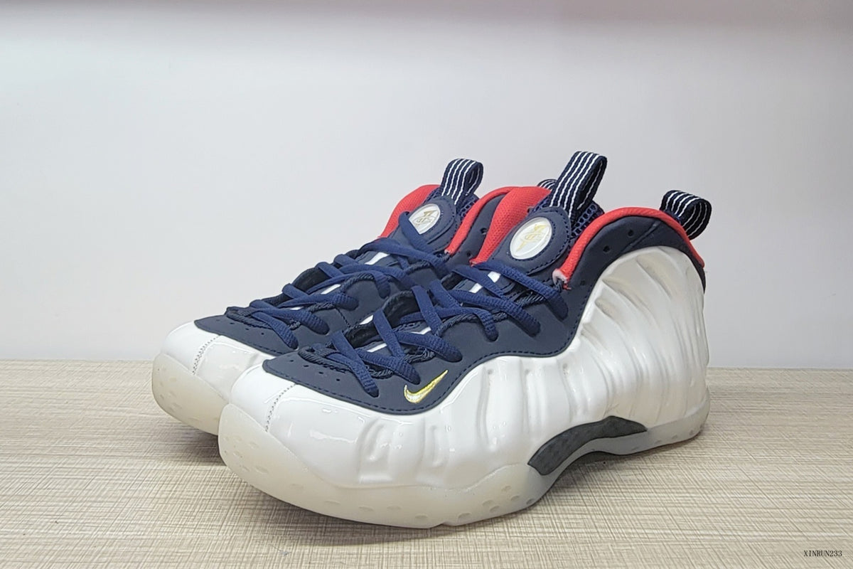 Pair of white Nike Air Foamposite One sneakers shown from a front three-quarter angle.