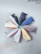 Group display of Nike Mind 002 kids sneakers in multiple colors and outsole combinations.