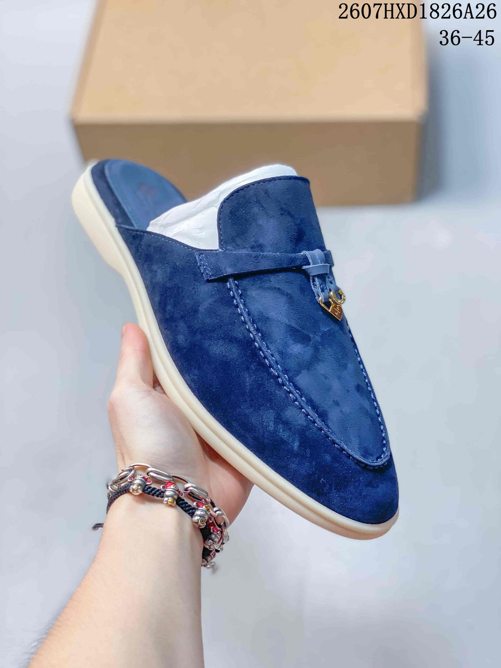 Close angled view of the navy suede-look upper, tonal stitching, vamp strap, open heel, and cream-colored sole.