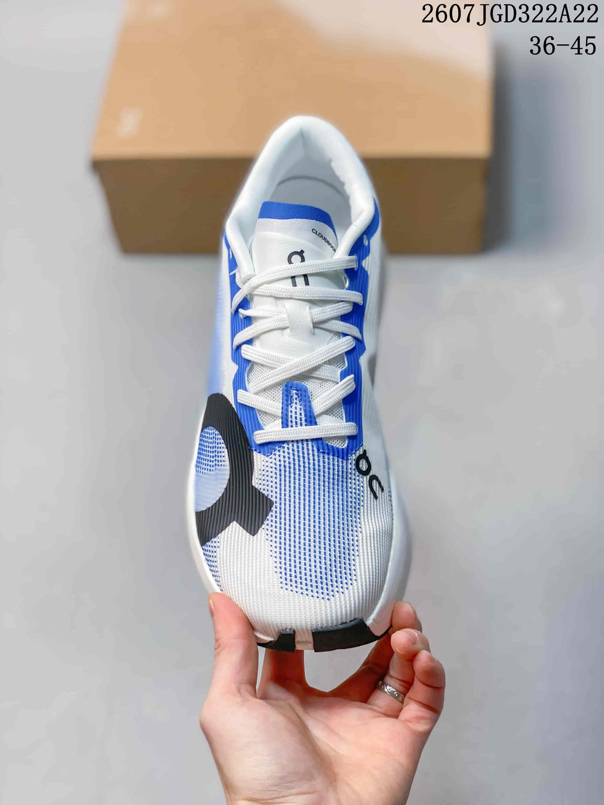 Top view of the shoe showing white laces, blue side panels, a white-and-blue upper and black forefoot detailing.