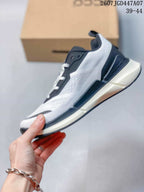 Side profile of the white and navy sneaker showing the layered midsole, lace-up closure, and color-block upper.
