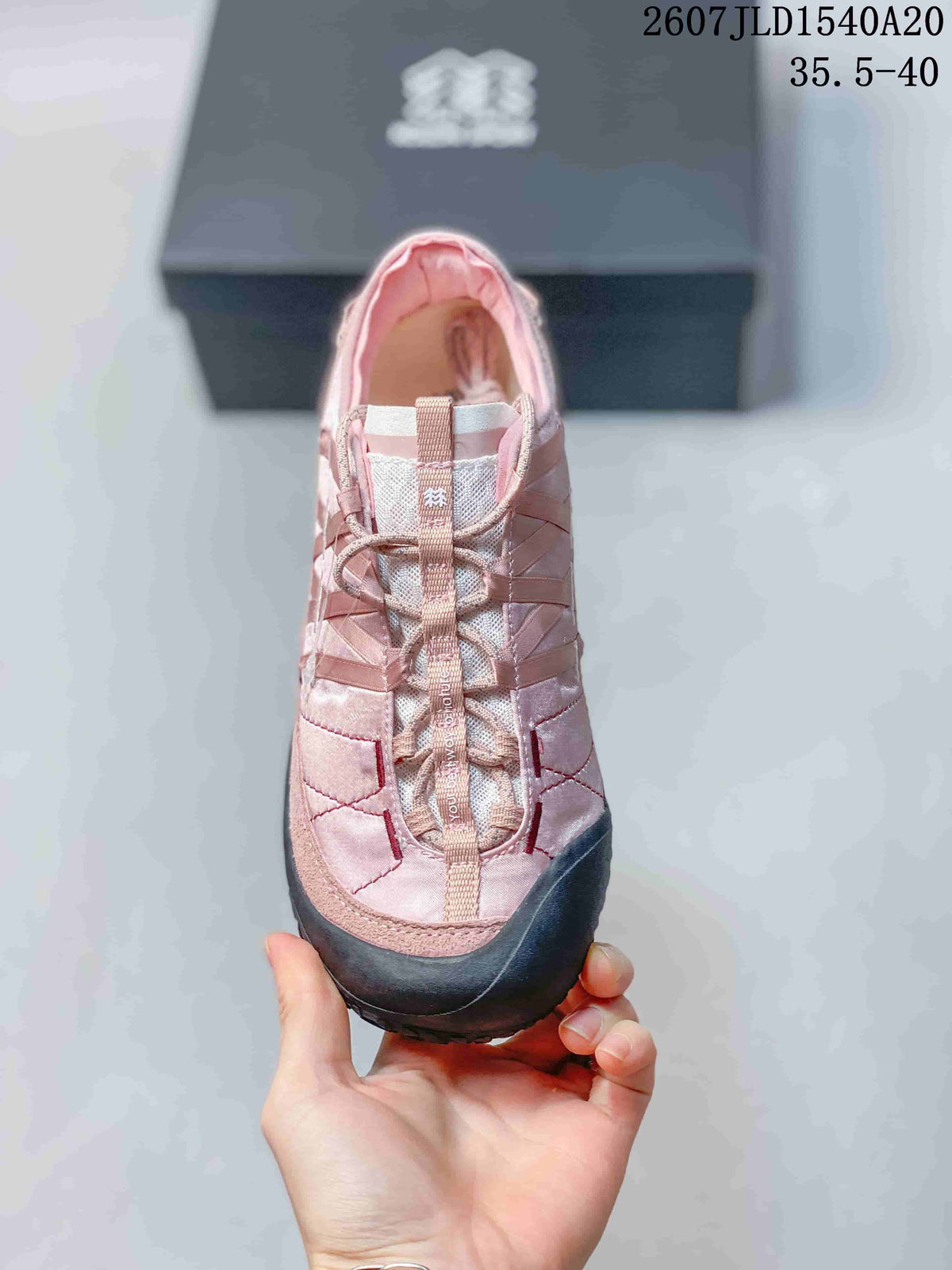Top view of the pink sneaker showing the lace arrangement, layered upper, and padded opening.